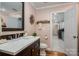 Bathroom with a wood vanity, marble top, and a view into the laundry room at 108 N Oakwood Dr, Kings Mountain, NC 28086