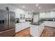 Bright kitchen with white cabinets, black countertops, a center island, and stainless-steel refrigerator at 108 N Oakwood Dr, Kings Mountain, NC 28086