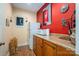 Compact kitchenette area with wood cabinets, a red accent wall and a small refrigerator at 108 N Oakwood Dr, Kings Mountain, NC 28086