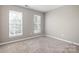 Neutral bedroom featuring plush carpeting and two windows that provide ample natural light at 12419 Swan Wings Pl, Huntersville, NC 28078