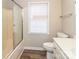 Bathroom features tiled shower with glass door, white toilet and vanity, and window at 136 Ole Eastpointe Dr, York, SC 29745