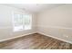 Bright bedroom with hardwood floors, window, neutral walls, and white trim at 136 Ole Eastpointe Dr, York, SC 29745