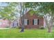 Brick home featuring a well-manicured lawn, mature trees, and traditional architecture at 136 Ole Eastpointe Dr, York, SC 29745