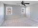 Spacious bedroom with carpet, a ceiling fan, two windows, and a double-door closet at 13732 Strathaven Dr, Matthews, NC 28105