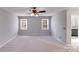 Large bedroom featuring two windows, neutral carpet, and access to the Primary bath at 13732 Strathaven Dr, Matthews, NC 28105