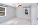 Neutral bedroom with two windows providing natural light, carpeted floors, and a ceiling fan at 13732 Strathaven Dr, Matthews, NC 28105