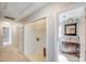 Hallway with a storage closet leading to a bathroom featuring a dark vanity and a white countertop at 13732 Strathaven Dr, Matthews, NC 28105