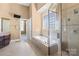 Bright bathroom features a soaking tub with shower and large dark wood vanity with granite countertops at 147 Pearl Bay Dr, New London, NC 28127