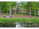 Secluded home with stone chimney, lush landscaping, and private pond view at 147 Pearl Bay Dr, New London, NC 28127