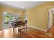 Elegant living room featuring a grand piano, hardwood floors, and patio access at 147 Pearl Bay Dr, New London, NC 28127