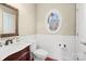 Charming powder room with decorative wainscoting, oval window, and hardwood floors at 147 Pearl Bay Dr, New London, NC 28127