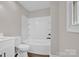 All-white bathroom features tub and shower combo, new fixtures, and modern design at 155 Country Ln, Mooresville, NC 28115