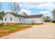 Side view of home with vinyl siding, brick foundation, wooden deck, and gravel driveway at 155 Country Ln, Mooresville, NC 28115