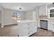 A white kitchen island complements stainless steel appliances, white cabinets, and stylish modern lighting at 155 Country Ln, Mooresville, NC 28115