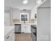 Bright kitchen featuring stainless steel appliances, white cabinets, tile backsplash and stylish modern lighting at 155 Country Ln, Mooresville, NC 28115