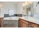 Bathroom featuring a soaking tub with tile surround and a vanity with a sink and wood cabinets at 1790 Faires Rd, Rock Hill, SC 29730