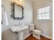 Bathroom with hardwood floors, toilet, pedestal sink, decorative mirror, and large window at 1790 Faires Rd, Rock Hill, SC 29730