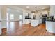 Modern kitchen featuring an island, white cabinetry, and a seamless transition to the adjacent living room at 1790 Faires Rd, Rock Hill, SC 29730