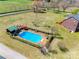 Aerial view of a sparkling pool with slide, cabana, and a windmill on a sprawling, manicured lawn at 1790 Faires Rd, Rock Hill, SC 29730