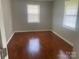 Inviting bedroom with gleaming hardwood floors and neutral walls, illuminated by two bright windows at 213 Crowell Ave, Albemarle, NC 28001