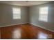 Well-lit bedroom with hardwood floors and two bright windows creating a cozy and inviting space at 213 Crowell Ave, Albemarle, NC 28001