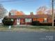 Charming single-story brick home with manicured landscaping, featuring a welcoming front porch at 213 Crowell Ave, Albemarle, NC 28001