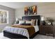 Modern bedroom featuring a black bed frame, textured bedding, and stylish bedside table with decor at 3012 Hutton Gardens Ln, Charlotte, NC 28269