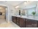 Bathroom featuring double sinks, a large mirror, and walk-in closet access at 3034 Oakmere Rd, Waxhaw, NC 28173