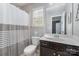 Cozy bathroom featuring a shower with curtain, white toilet, sink, mirror, and neutral-colored walls at 3034 Oakmere Rd, Waxhaw, NC 28173