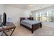 This bedroom features neutral carpet, light walls, and a bed with a brown wood frame and desk at 3034 Oakmere Rd, Waxhaw, NC 28173