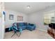 Living room features a plush blue couch, a flat screen TV, a window, and neutral colored walls at 3034 Oakmere Rd, Waxhaw, NC 28173