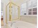 Luxurious bathroom with a soaking tub and a glass-enclosed shower with gold trim at 3222 Shadow Lake Ln, Matthews, NC 28104