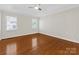 Bright bedroom featuring hardwood floors, a ceiling fan, and ample natural light from two windows at 3222 Shadow Lake Ln, Matthews, NC 28104