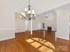 Dining room with hardwood floors, large chandelier and natural light with views into living spaces at 3222 Shadow Lake Ln, Matthews, NC 28104