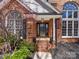 Close-up of the home's front entrance, highlighting the brick facade, steps and decorative plants at 3222 Shadow Lake Ln, Matthews, NC 28104