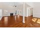 Open living room with hardwood floors, fireplace, windows, ceiling fan and column accents at 3222 Shadow Lake Ln, Matthews, NC 28104