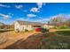 This backyard has a gravel area with a carport and 3 vehicles parked on it and grass growing nearby at 340 W Memorial Hwy, Harmony, NC 28634