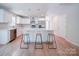 Bright, modern kitchen with white cabinets, stainless appliances, and large center island with bar stool seating at 406 White Store Rd, Wadesboro, NC 28170