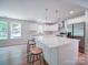 Bright kitchen with white cabinets, quartz countertops, stainless steel appliances, and a breakfast bar at 406 White Store Rd, Wadesboro, NC 28170