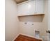 This is a photo of the laundry room with white cabinets and wood-style flooring at 406 White Store Rd, Wadesboro, NC 28170