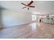 Large living room with light hardwood floors and ceiling fan that leads to an open kitchen and dining area at 406 White Store Rd, Wadesboro, NC 28170