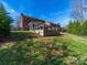 Landscaped backyard featuring well-maintained lawn, complemented by a wooden deck for outdoor enjoyment at 4127 Stacy Blvd, Charlotte, NC 28209