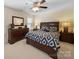 Spacious bedroom with a bed, dresser and end tables bathed in light from a sunny window at 4127 Stacy Blvd, Charlotte, NC 28209