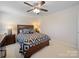 Comfortable bedroom featuring a ceiling fan, bedside table, and a stylish, patterned comforter at 4127 Stacy Blvd, Charlotte, NC 28209