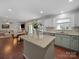 Well-lit kitchen with granite island, white cabinets, stainless steel appliances, and view of the open floor plan at 4127 Stacy Blvd, Charlotte, NC 28209