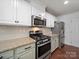 Kitchen featuring white cabinets, granite countertops, stainless steel appliances, tile backsplash, and hardwood floors at 4127 Stacy Blvd, Charlotte, NC 28209