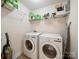 Efficient laundry room showcasing a modern washer and dryer set, along with shelving for storage at 4127 Stacy Blvd, Charlotte, NC 28209