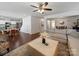 Open-concept living area with hardwood floors, a modern sofa, and seamless flow to the kitchen at 4127 Stacy Blvd, Charlotte, NC 28209