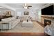 Bright living room featuring a sectional, stacked stone fireplace, and large windows at 4127 Stacy Blvd, Charlotte, NC 28209