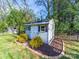 Exterior view of shed with white door, windows, and surrounding landscaping with mulch and green bushes at 4127 Stacy Blvd, Charlotte, NC 28209